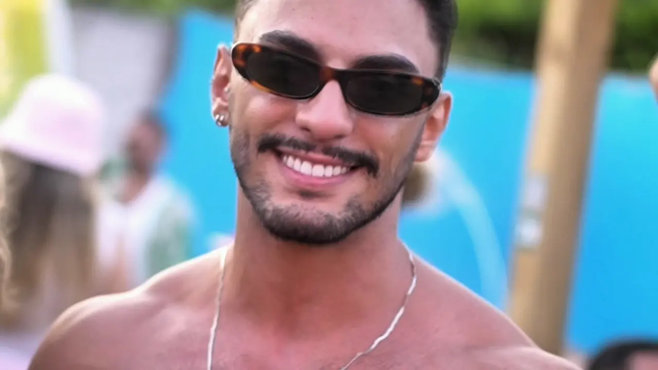 Homem sorrindo de óculos escuros na pista de dia