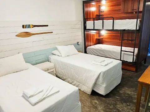 Quarto com beliches de madeira e camas de solteiro
